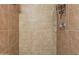 Close-up of the shower with neutral-tone tiled walls and an adjustable shower head and shelf at 7977 W Wacker Rd # 220, Peoria, AZ 85381