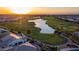 Aerial view of a lush golf course community featuring lakes, a green, and residential homes at sunset at 805 E La Palta St, Queen Creek, AZ 85140