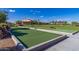 A community bocce ball court with a lush lawn and inviting clubhouse in the background at 805 E La Palta St, Queen Creek, AZ 85140