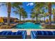 Beautiful community pool area with palm trees, inviting lounge chairs, and shade umbrellas for residents at 805 E La Palta St, Queen Creek, AZ 85140