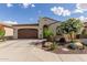 Charming single-story home featuring a well-manicured desert landscape and brown two car garage at 805 E La Palta St, Queen Creek, AZ 85140