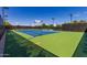 A vibrant green and blue tennis court is framed by black fencing and light fixtures at 805 E La Palta St, Queen Creek, AZ 85140