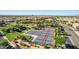 Scenic aerial view of a community with tennis courts, a clubhouse, a pool, and inviting green spaces at 805 E La Palta St, Queen Creek, AZ 85140
