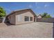 View of the gravel backyard, complete with block fence and mature tree landscaping at 8733 W Laurel Ln, Peoria, AZ 85345