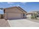 Inviting home featuring a two-car garage and low-maintenance desert landscaping at 8733 W Laurel Ln, Peoria, AZ 85345