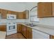 Kitchen featuring wood cabinets, white appliances, and a stainless-steel sink at 8733 W Laurel Ln, Peoria, AZ 85345