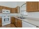 Kitchen featuring wood cabinets, white appliances, and a stainless-steel sink at 8733 W Laurel Ln, Peoria, AZ 85345