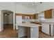 Kitchen featuring white appliances, wood cabinets, and an island with bar seating at 8733 W Laurel Ln, Peoria, AZ 85345