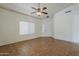Open living room with tile flooring, ceiling fan, and window with blinds at 8733 W Laurel Ln, Peoria, AZ 85345