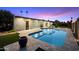 A backyard features a sparkling pool, artificial grass, and a travertine deck at 10245 N 34Th Pl, Phoenix, AZ 85028