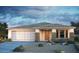 Charming single-story home showcasing stone accents, a two-car garage, and desert landscaping at 10909 S 52Nd Dr, Laveen, AZ 85339