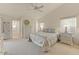 Bright bedroom with neutral carpet, ceiling fan, and large windows at 15695 W Earll Dr, Goodyear, AZ 85395