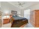 Bedroom with a queen size bed, ceiling fan, window, and wood furniture at 15695 W Earll Dr, Goodyear, AZ 85395