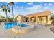 Beautiful backyard pool and spa next to outdoor seating, with palm trees overhead at 15695 W Earll Dr, Goodyear, AZ 85395