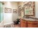 This bathroom features decorative sconces, artwork, and a vanity with a marble countertop and an ornate mirror at 15802 N 71St St # 657, Scottsdale, AZ 85254
