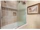 This bathroom features a glass door, tiled walls, a built-in soap box, and a framed artwork on the wall at 15802 N 71St St # 657, Scottsdale, AZ 85254