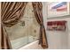 Bathroom featuring bathtub with curtain and decorative tile surround at 15802 N 71St St # 657, Scottsdale, AZ 85254