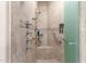Modern bathroom shower with multiple shower heads, frosted glass door, and convenient handrail at 15802 N 71St St # 657, Scottsdale, AZ 85254
