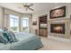 Primary bedroom with a cozy fireplace, mounted TV, and golf course views at 15802 N 71St St # 657, Scottsdale, AZ 85254