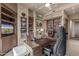 This office features built-in shelving, a ceiling fan, artwork, and a large desk for comfortable remote working at 15802 N 71St St # 657, Scottsdale, AZ 85254