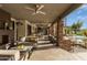 This covered patio features ceiling fans, an outdoor fireplace, cozy seating, and a view of the backyard pool at 15802 N 71St St # 657, Scottsdale, AZ 85254