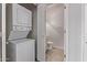 A laundry room with white stacked washer and dryer next to a half bathroom at 1633 E Lakeside Dr # 143, Gilbert, AZ 85234