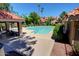 Community pool with a covered lounge area and many chairs for residents to enjoy under the sunny sky at 1633 E Lakeside Dr # 143, Gilbert, AZ 85234