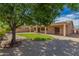 The backyard features an expansive gravel area with a grass lawn, mature shade trees, and a covered patio at 16837 W Northampton Rd, Surprise, AZ 85374