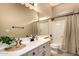 Well-lit bathroom features a large mirror, shower-tub combo, and vanity with sink at 16837 W Northampton Rd, Surprise, AZ 85374