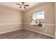 The bedroom includes a ceiling fan, and window offering a glimpse of the neighborhood at 16837 W Northampton Rd, Surprise, AZ 85374