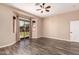 Bedroom featuring wood-look flooring, neutral walls, ceiling fan, and sliding glass door at 16837 W Northampton Rd, Surprise, AZ 85374