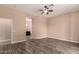 Bedroom features wood-look flooring, neutral walls, ceiling fan, and ensuite bathroom at 16837 W Northampton Rd, Surprise, AZ 85374