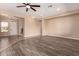Bright living room featuring wood-look flooring, neutral walls, and a ceiling fan at 16837 W Northampton Rd, Surprise, AZ 85374