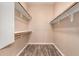 Spacious walk-in closet featuring custom shelving and wood-look flooring for organized storage at 16837 W Northampton Rd, Surprise, AZ 85374