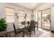 Bright dining room with glass table, six chairs, and sliding door to patio at 18077 W Sammy Way, Surprise, AZ 85374