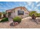 Charming home exterior with a well-manicured desert landscape, including a palm tree and rock accents at 18077 W Sammy Way, Surprise, AZ 85374
