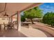 Covered patio with an outdoor dining set, providing a relaxing space with scenic backyard views at 18077 W Sammy Way, Surprise, AZ 85374