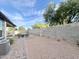 Desert backyard featuring gravel, pavers, a seating area, block wall, and lush trees at 18100 N Piccolo Dr, Maricopa, AZ 85138