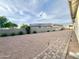 Large backyard with gravel, pavers, lush landscaping and a privacy wall at 18100 N Piccolo Dr, Maricopa, AZ 85138