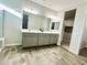 Bathroom featuring double vanity, wood-look ceramic tile flooring, and neutral color palette at 18100 N Piccolo Dr, Maricopa, AZ 85138