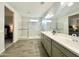 Bathroom with double vanity, walk-in shower, and view of main bedroom at 18100 N Piccolo Dr, Maricopa, AZ 85138