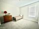 Neutral bedroom featuring a twin bed, wooden dresser, and bright, natural light at 18100 N Piccolo Dr, Maricopa, AZ 85138