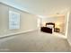 Bright bedroom featuring a large window, neutral walls, and soft carpeting at 18100 N Piccolo Dr, Maricopa, AZ 85138
