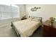 Bedroom with a metal frame bed, dark dresser, and neutral carpet at 18100 N Piccolo Dr, Maricopa, AZ 85138