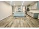 Open kitchen with stainless appliances, gray cabinets, and a central island, with wood-look flooring at 18100 N Piccolo Dr, Maricopa, AZ 85138