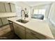 Kitchen island features light gray cabinets, quartz countertop, and stainless steel appliances in an open layout at 18100 N Piccolo Dr, Maricopa, AZ 85138