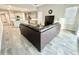 Open-concept living area showcases modern sectional sofa, bright kitchen, and tile flooring at 18100 N Piccolo Dr, Maricopa, AZ 85138