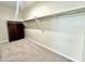 Walk-in closet with clothes rods, shelves and dark wood-stained chest of drawers at 18100 N Piccolo Dr, Maricopa, AZ 85138