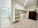 Bedroom with view of bathroom, walk-in closet, clothes rods, shelves and carpet at 18100 N Piccolo Dr, Maricopa, AZ 85138