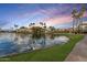 Scenic lakeside community featuring lush landscaping and palm trees against a vibrant sunset backdrop at 1825 W Ray Rd # 2132, Chandler, AZ 85224